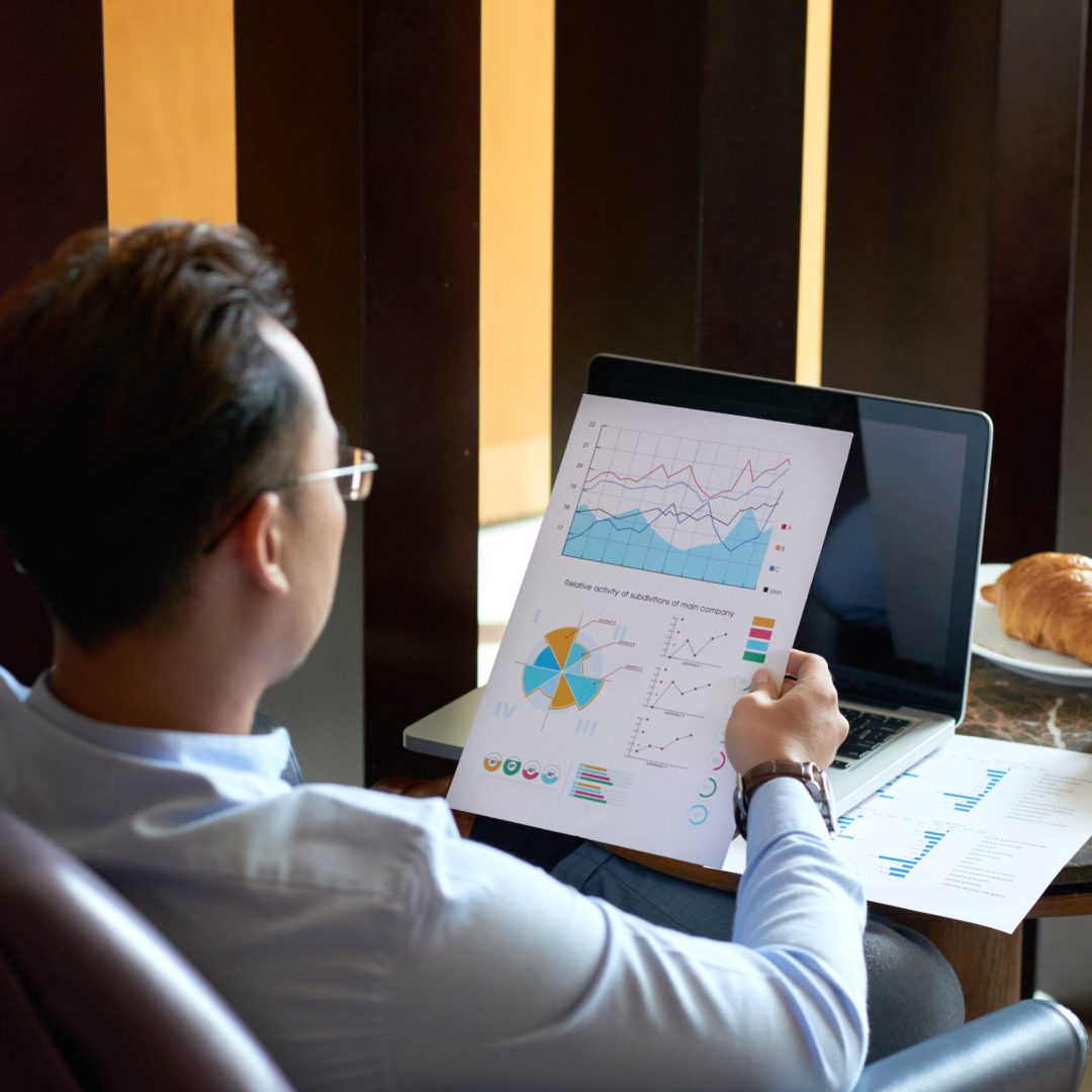 Entrepreneur looking at document with diagram in his hand